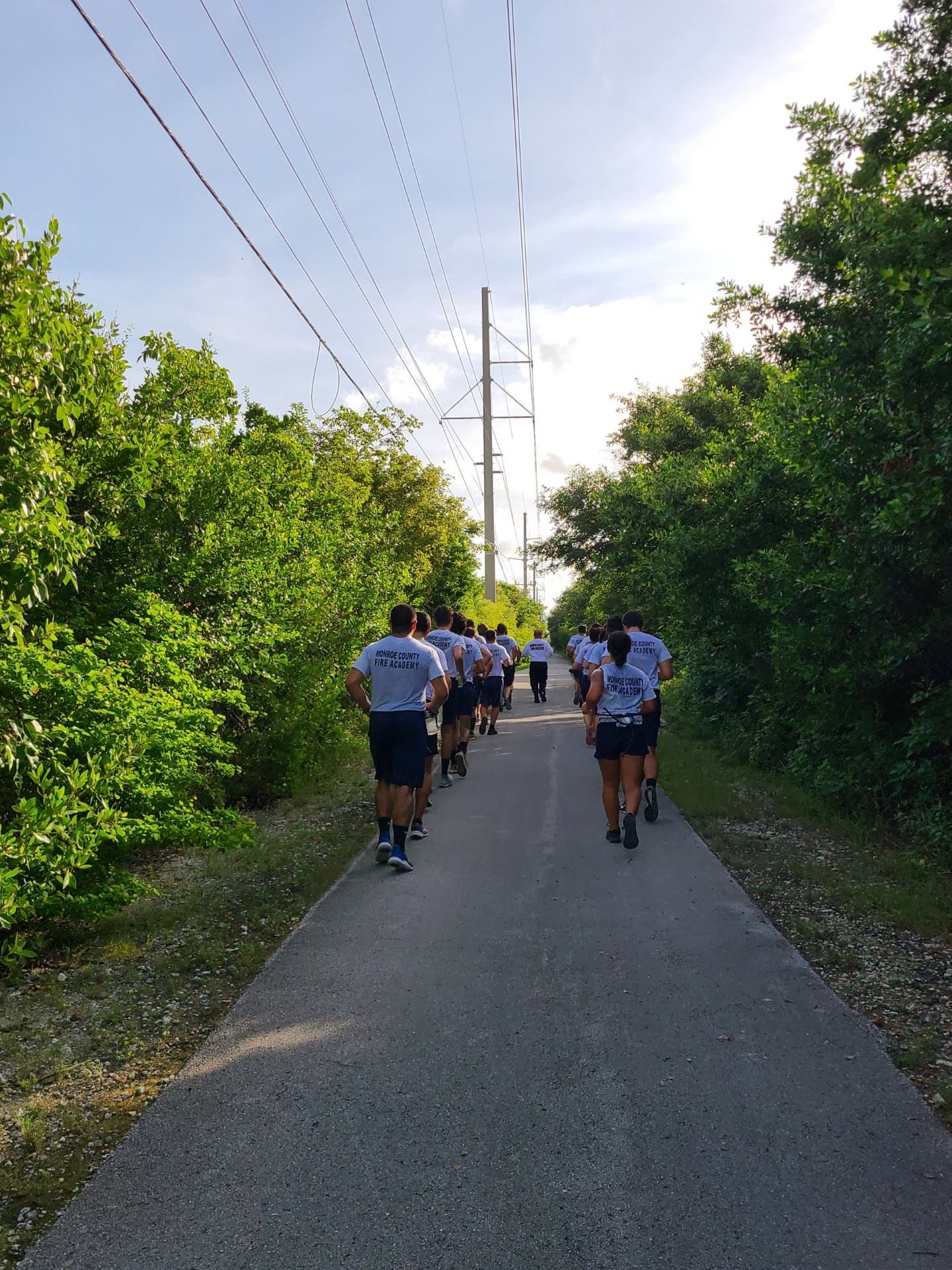The Hot Shots run in two lines down a sidewalk to train.